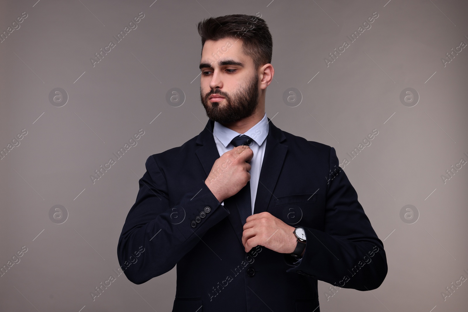 Photo of Handsome businessman in suit and necktie on grey background