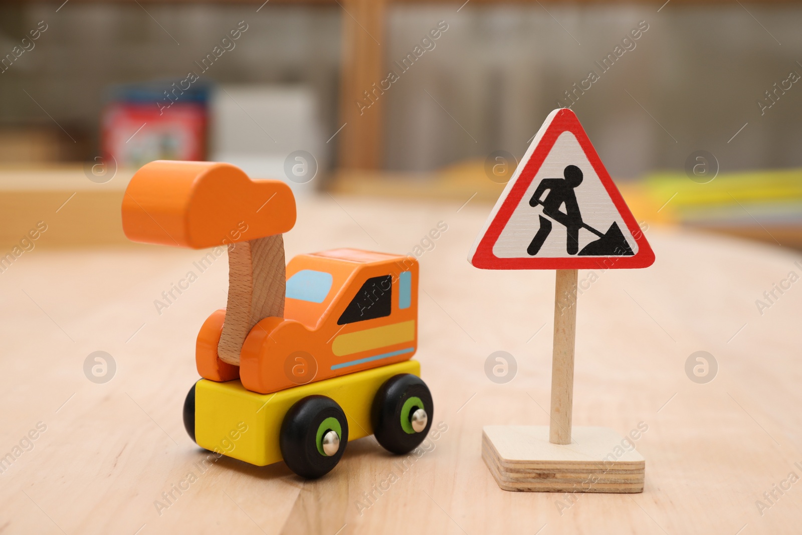 Photo of Miniature road sign and vehicle on wooden table, closeup. Montessori toy