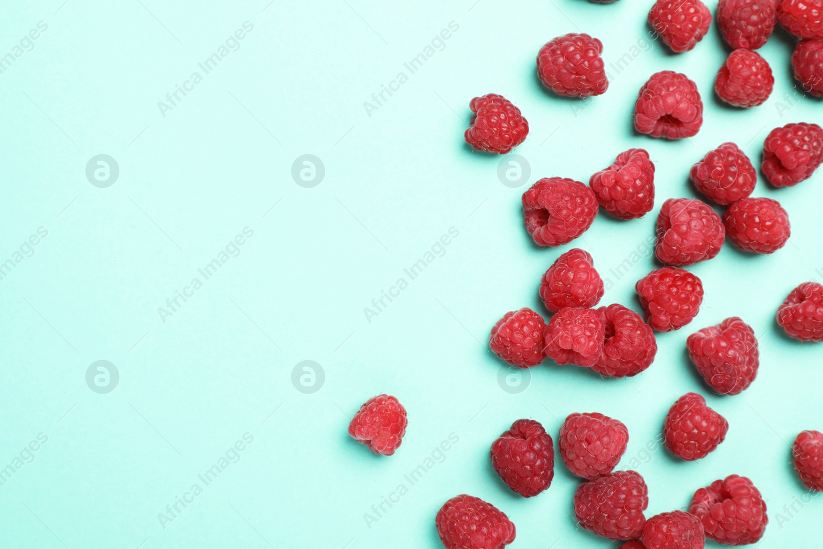 Photo of Flat lay composition with ripe aromatic raspberries on color background