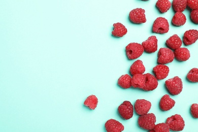 Flat lay composition with ripe aromatic raspberries on color background