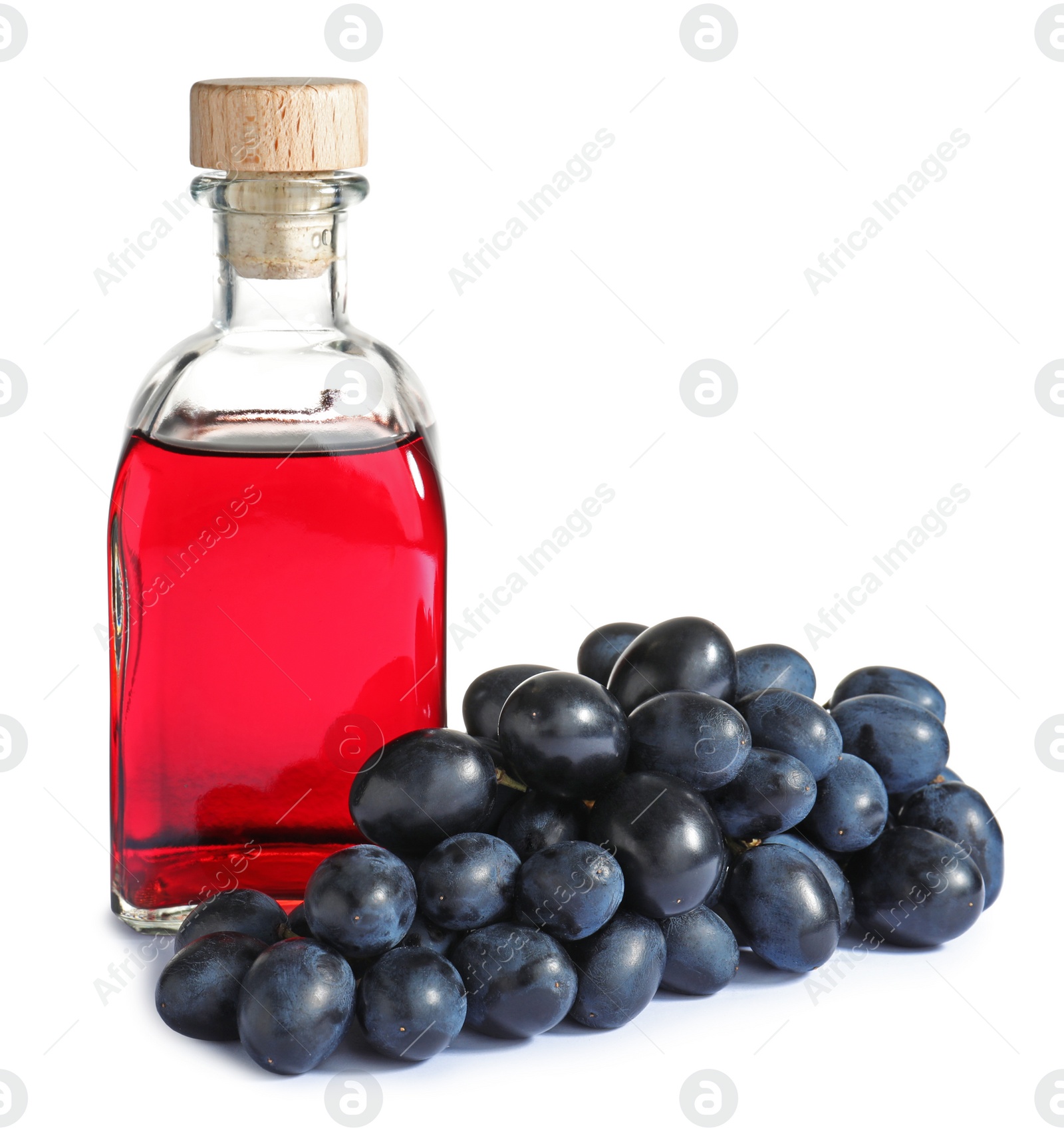 Photo of Bottle with wine vinegar and fresh grapes on white background