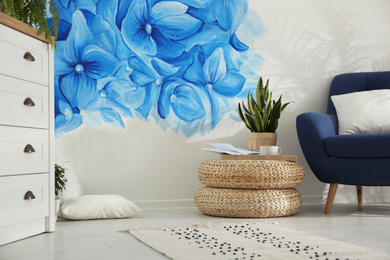 Stylish living room with blue flowers painted on wall. Floral pattern in interior design