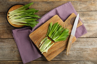 Photo of Flat lay composition with wild garlic or ramson on wooden table