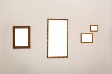 Frames with empty canvases on wall in modern art gallery. Mockup for design