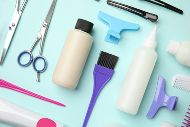 Photo of Professional tools for hair dyeing on light blue background, flat lay