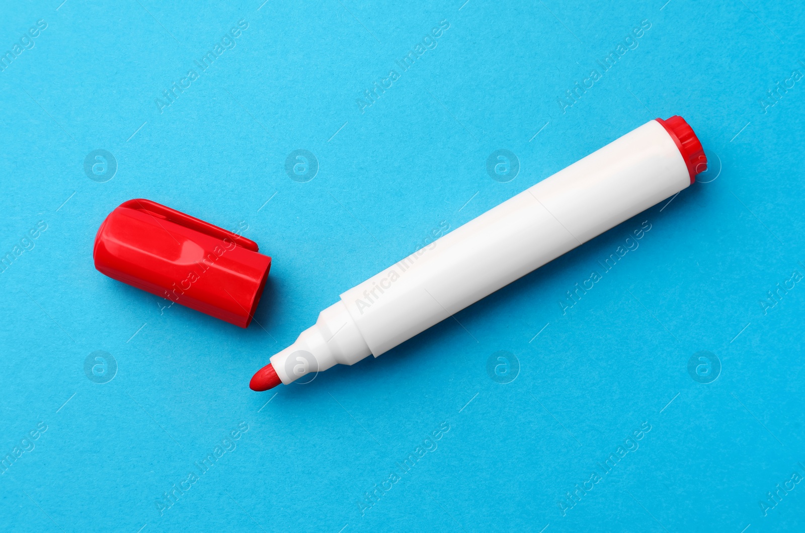 Photo of Bright red marker on light blue background, flat lay
