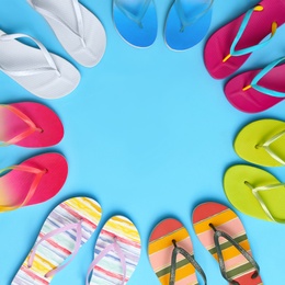 Photo of Flat lay composition with different flip flops on blue background, space for text. Summer beach accessories