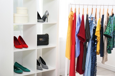 Photo of Shelving unit with shoes and purses in stylish dressing room interior