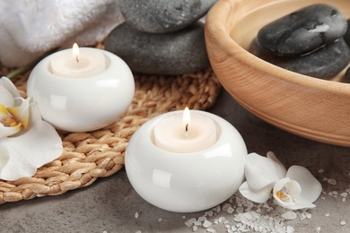 Composition with spa stones and candles on gray table