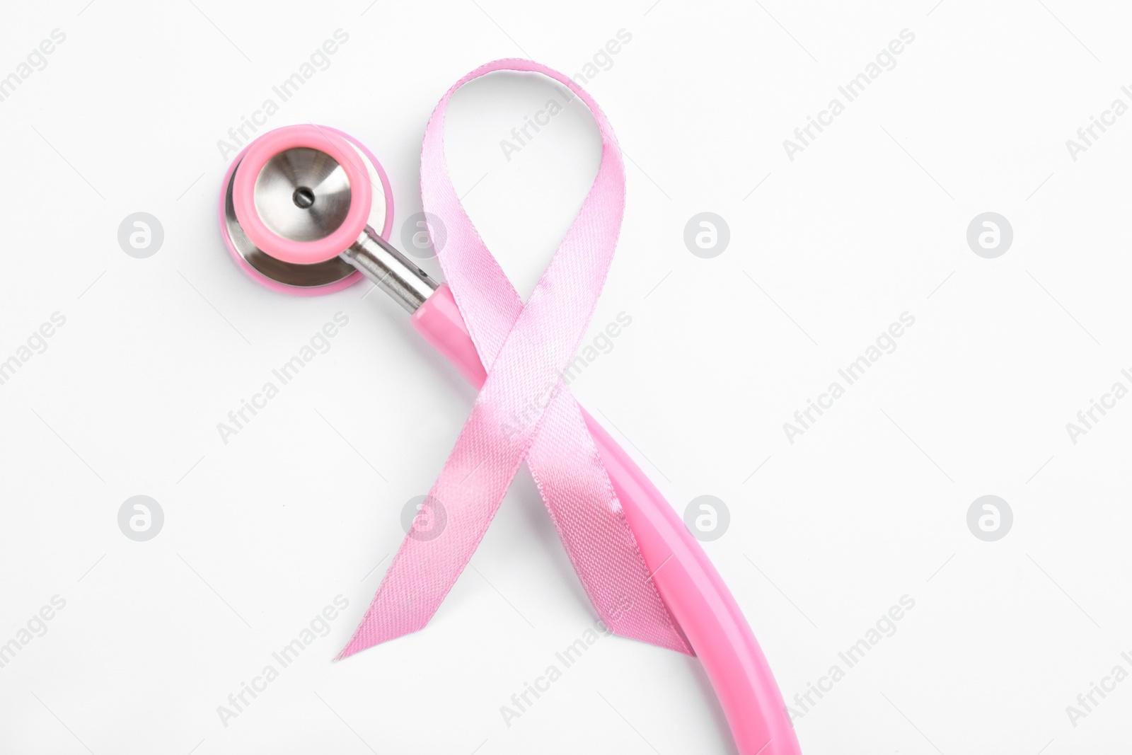 Photo of Pink ribbon and stethoscope on white background, top view. Breast cancer awareness