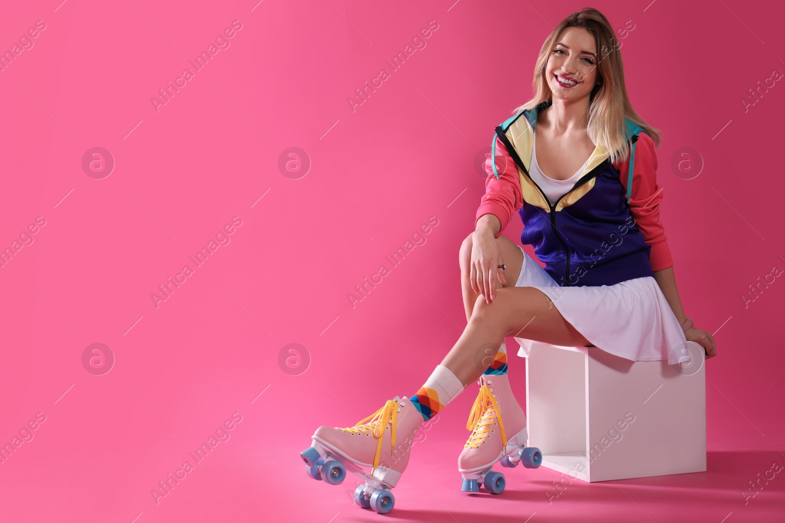 Photo of Young woman with retro roller skates on color background. Space for text