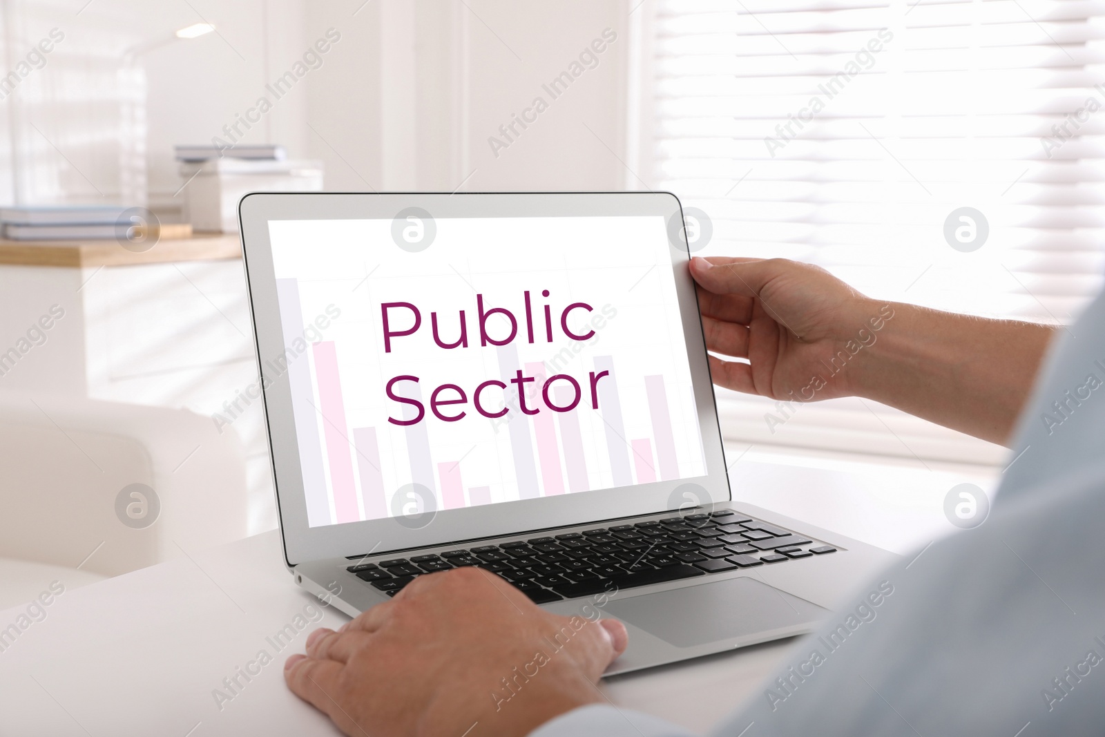 Image of Public Sector. Man working with modern laptop at white table, closeup 