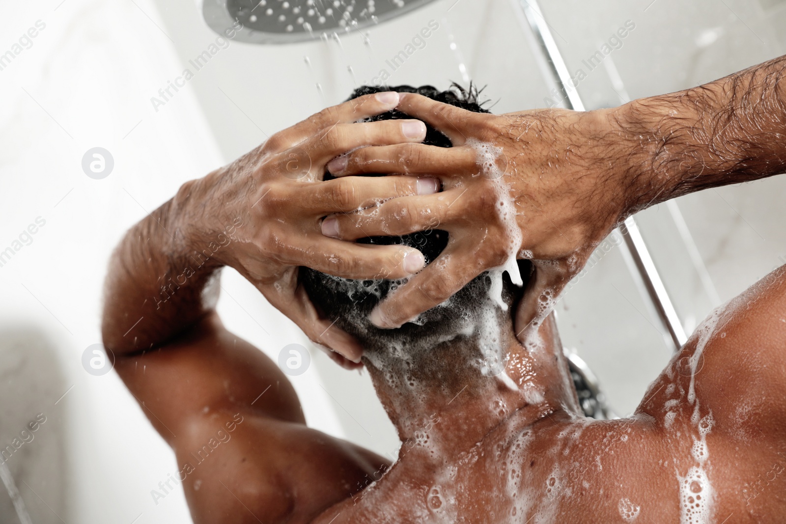 Photo of Man washing hair in shower at home, closeup