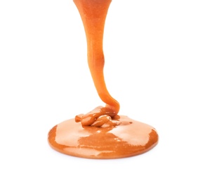 Photo of Pouring caramel sauce onto white background