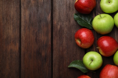 Photo of Fresh ripe apples on wooden table, flat lay. Space for text