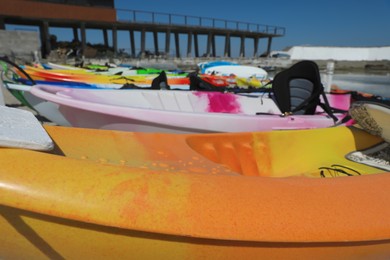 Photo of Many colorful kayaks near sea, closeup view