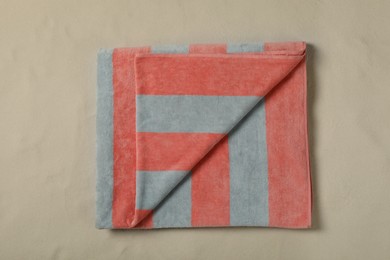 Photo of Striped beach towel on sand, top view