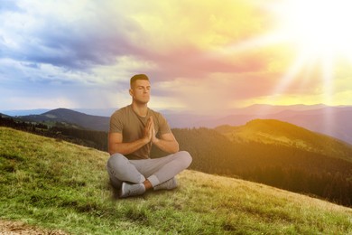Image of Man meditating in mountains at sunrise, space for text
