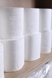 Photo of Stacked toilet paper rolls on wooden shelf