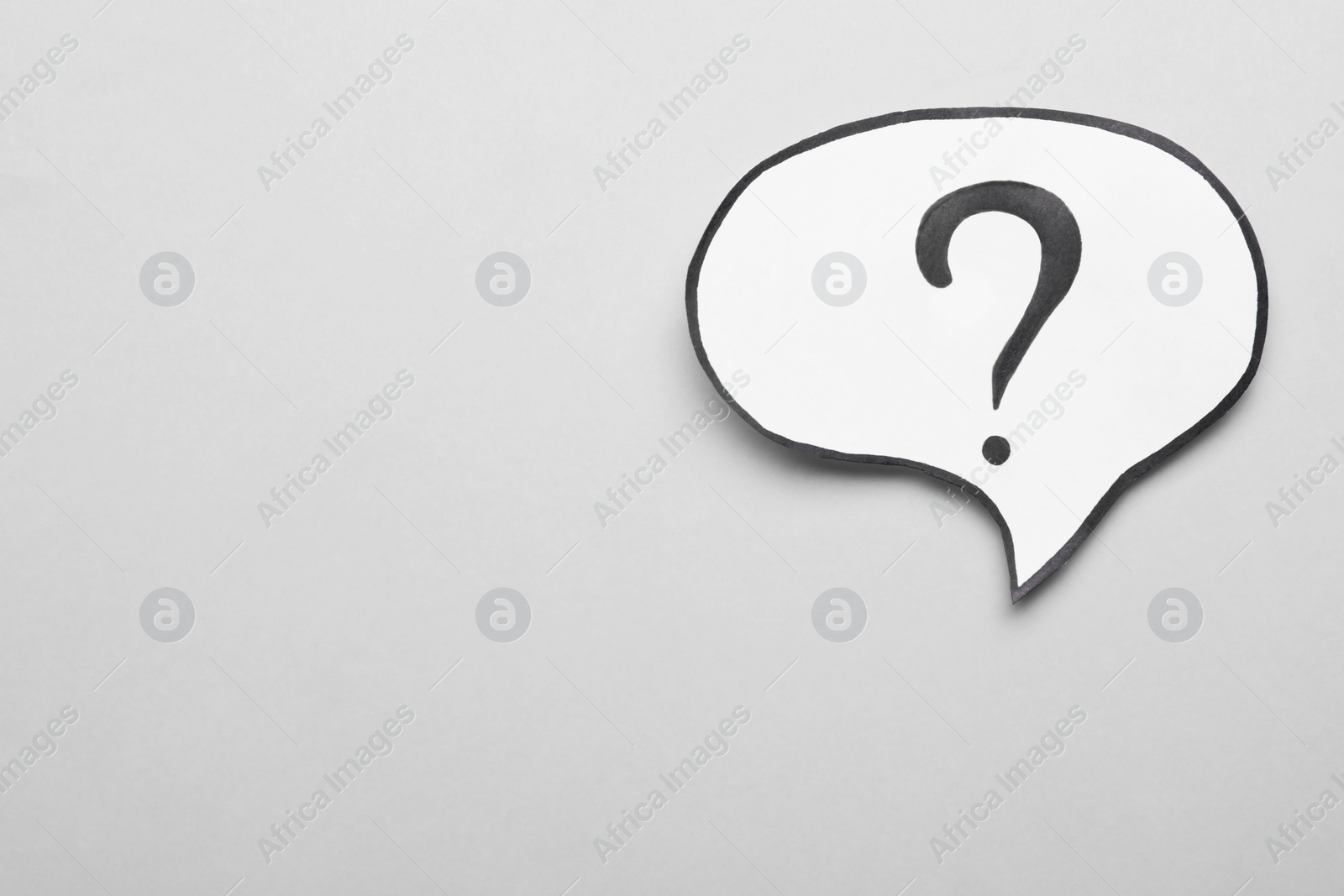 Photo of Paper speech bubble with question mark on light grey background, top view. Space for text