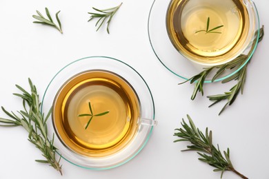 Photo of Cups of aromatic herbal tea with rosemary on white table, flat lay