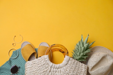 Photo of Stylish straw bag and summer accessories on yellow background, flat lay. Space for text
