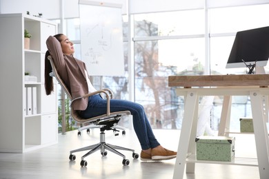 Young woman relaxing in office chair at workplace