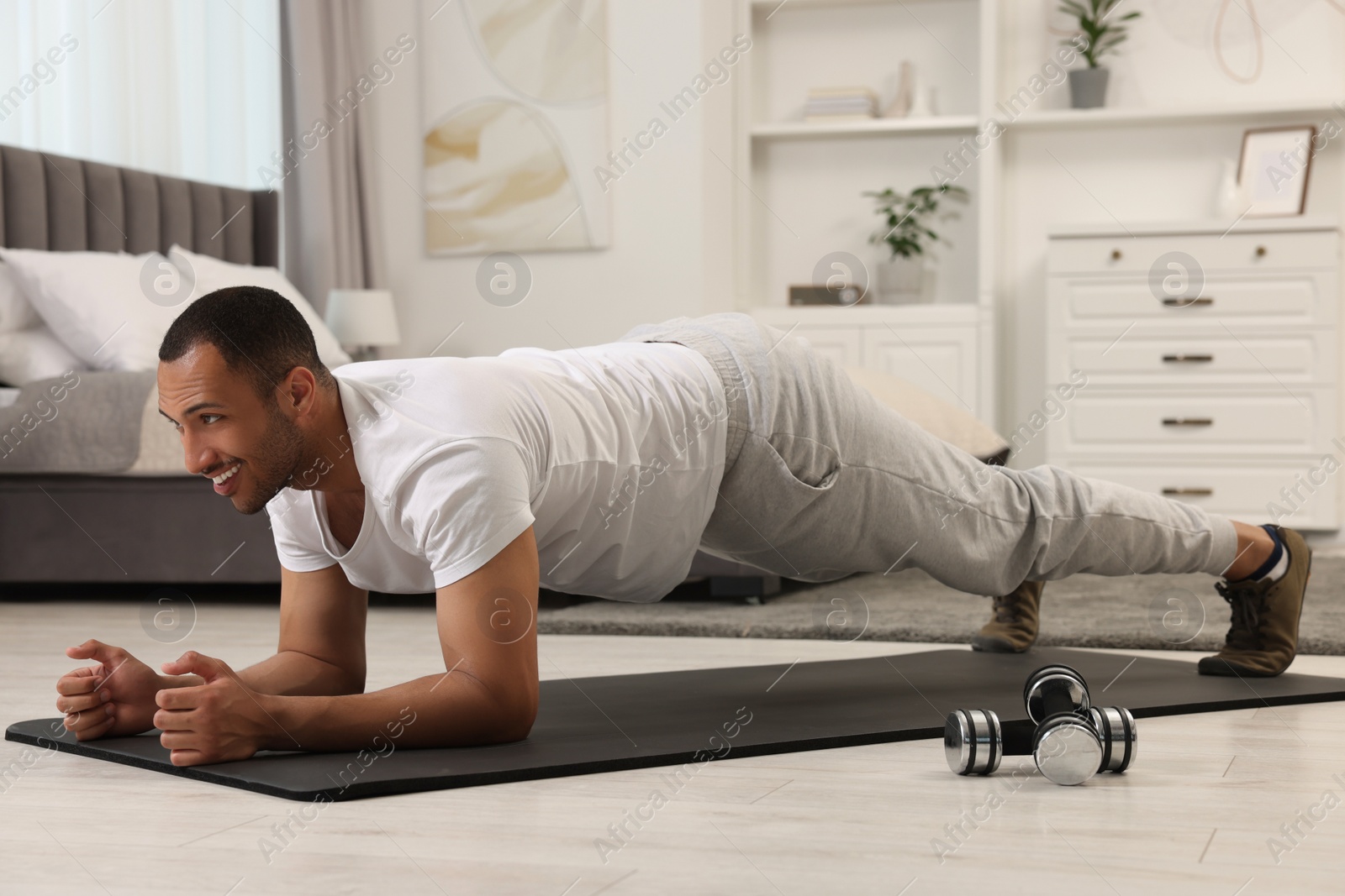 Photo of Man doing morning exercise on fitness mat at home