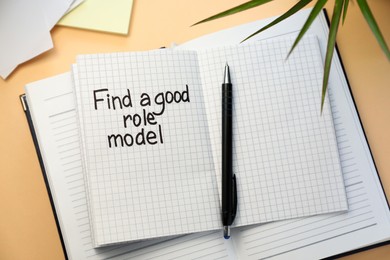 Photo of Notebook with phrase Find A Good Role Model and pen on beige background, flat lay