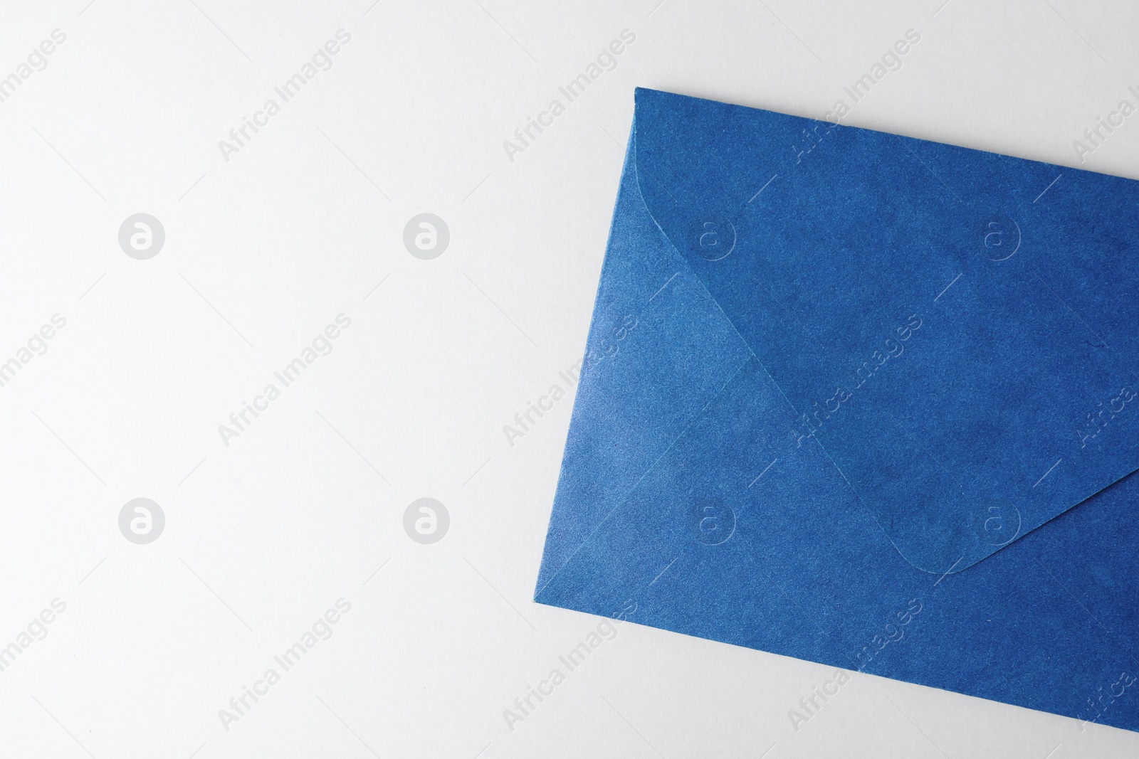 Photo of Blue paper envelope on light background, top view. Space for text