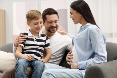 Pregnant woman spending time with her son and husband at home