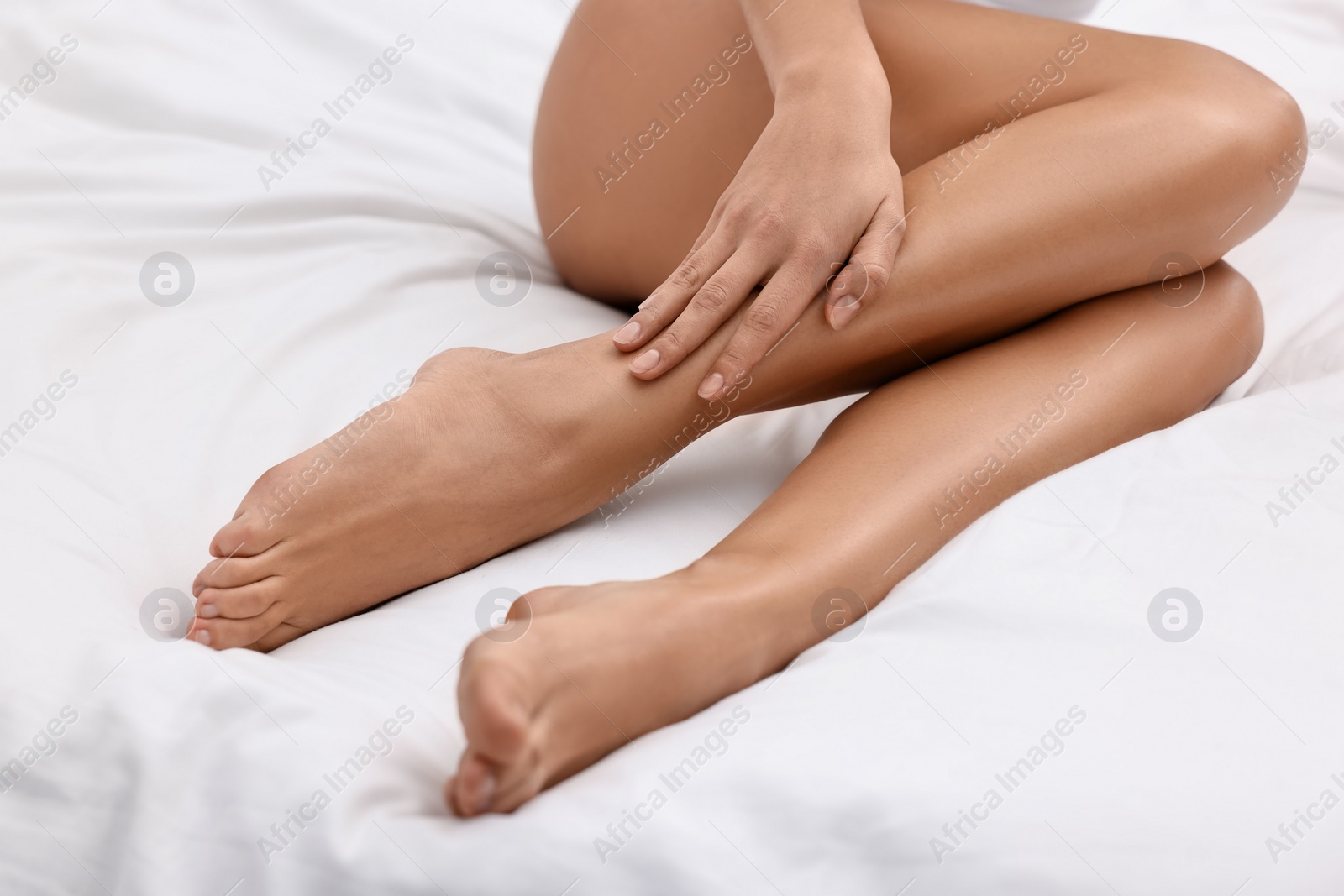 Photo of Woman with beautiful legs in bed, closeup