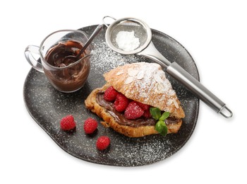 Photo of Delicious croissant with raspberries, chocolate and powdered sugar isolated on white, above view