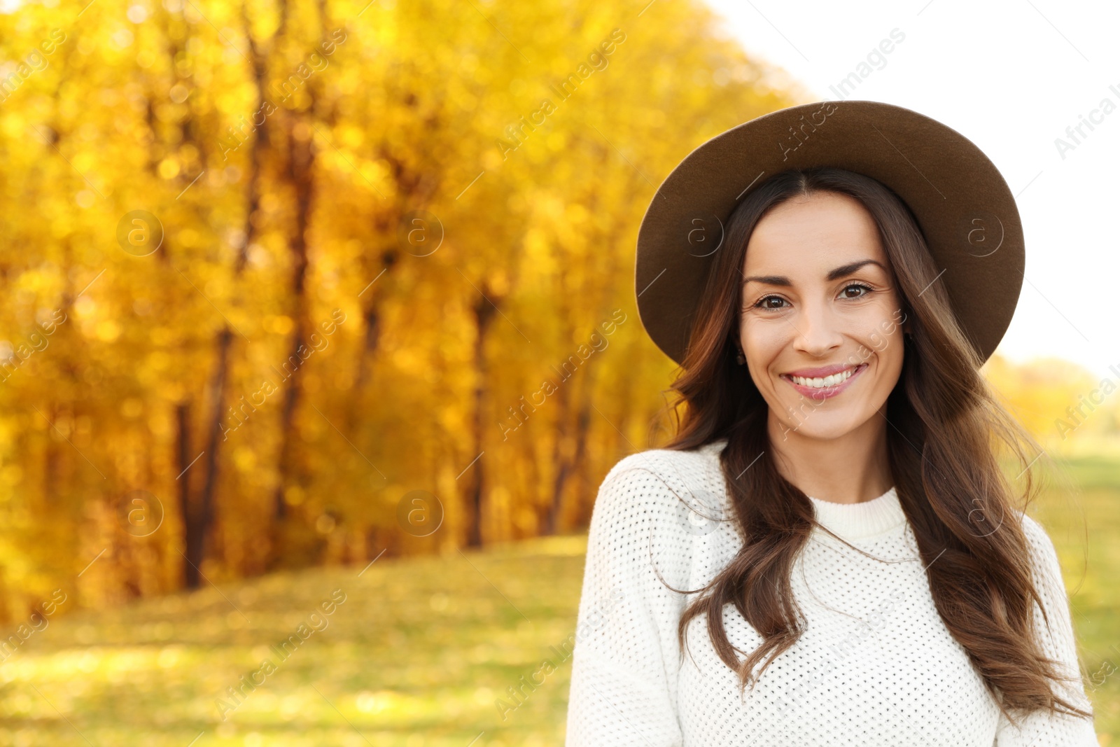 Photo of Beautiful happy woman wearing hat in park. Autumn walk