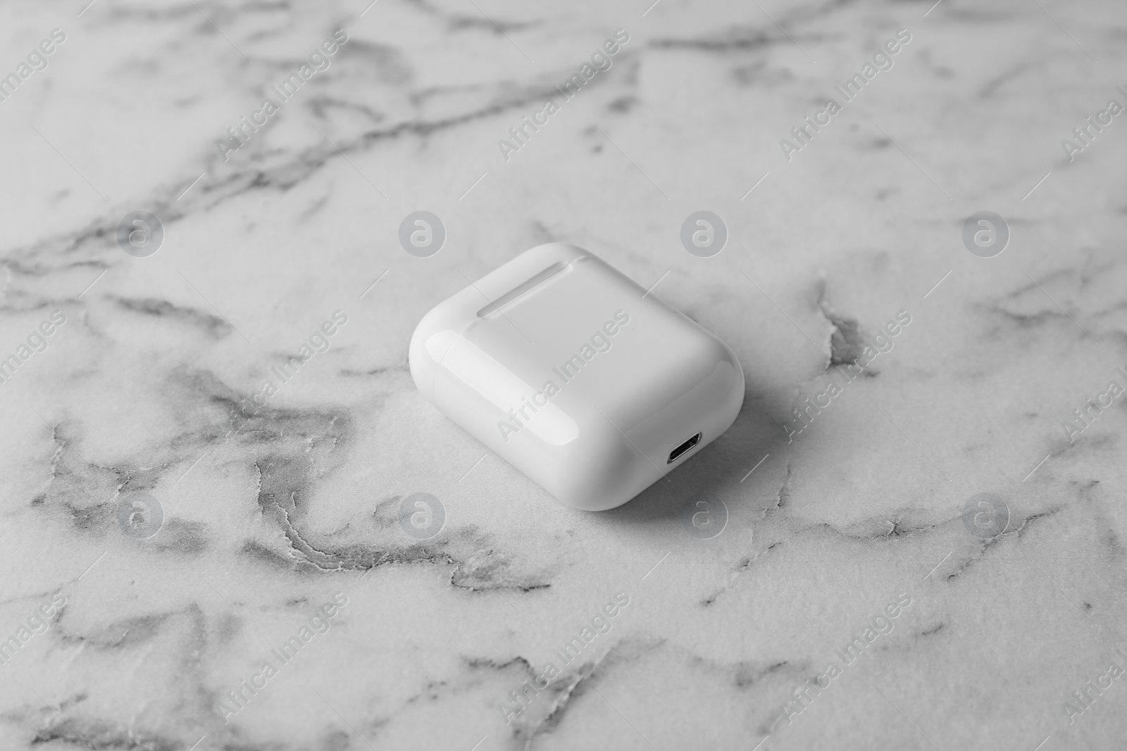 Photo of Charging case for wireless earphones on marble table