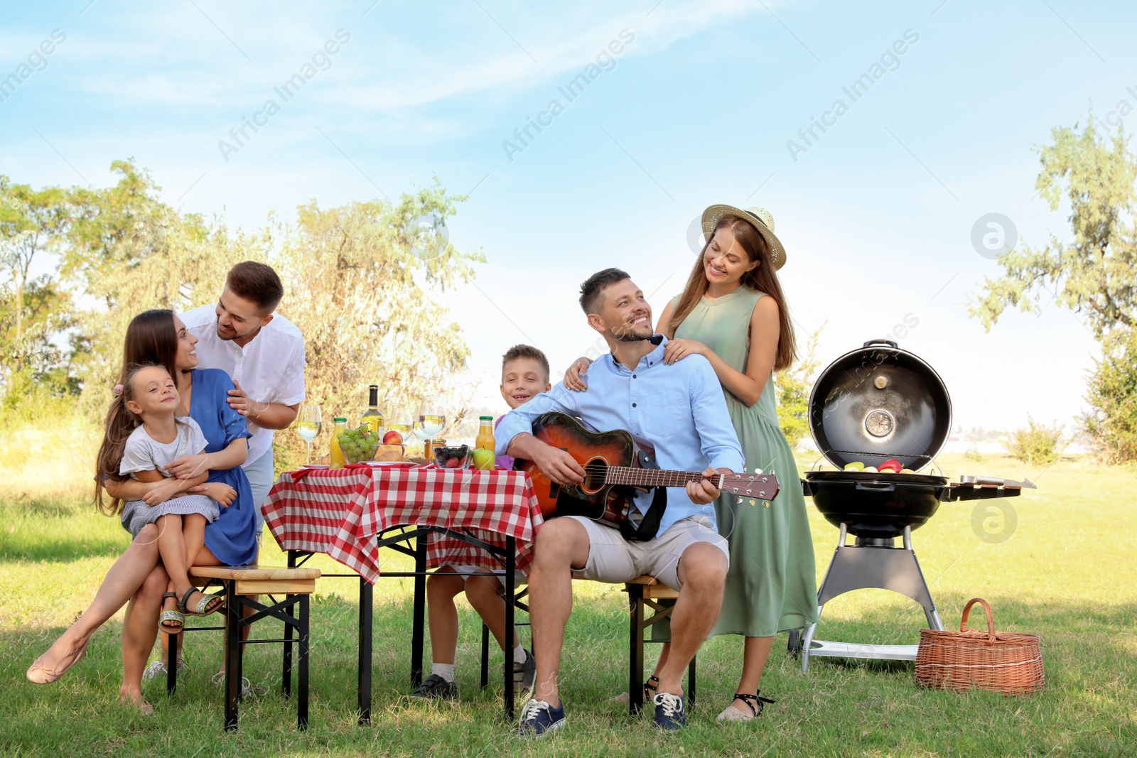 Photo of Happy families with little children having picnic in park