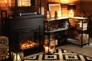 Photo of Beautiful fireplace and different decor in living room at night. Interior design