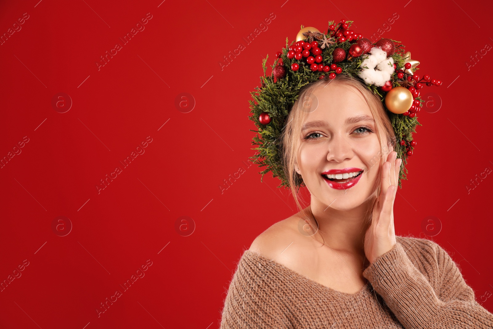 Photo of Beautiful young woman wearing Christmas wreath on red background. Space for text