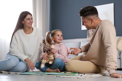 Photo of Happy family with little daughter spending time together at home. Floor heating concept