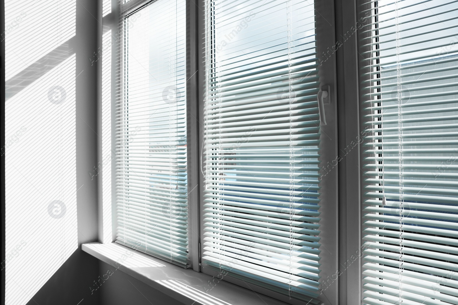 Photo of Stylish window with horizontal blinds in room