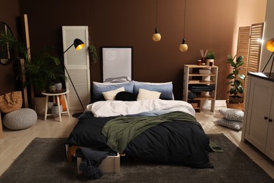 Stylish room interior with large bed near brown wall