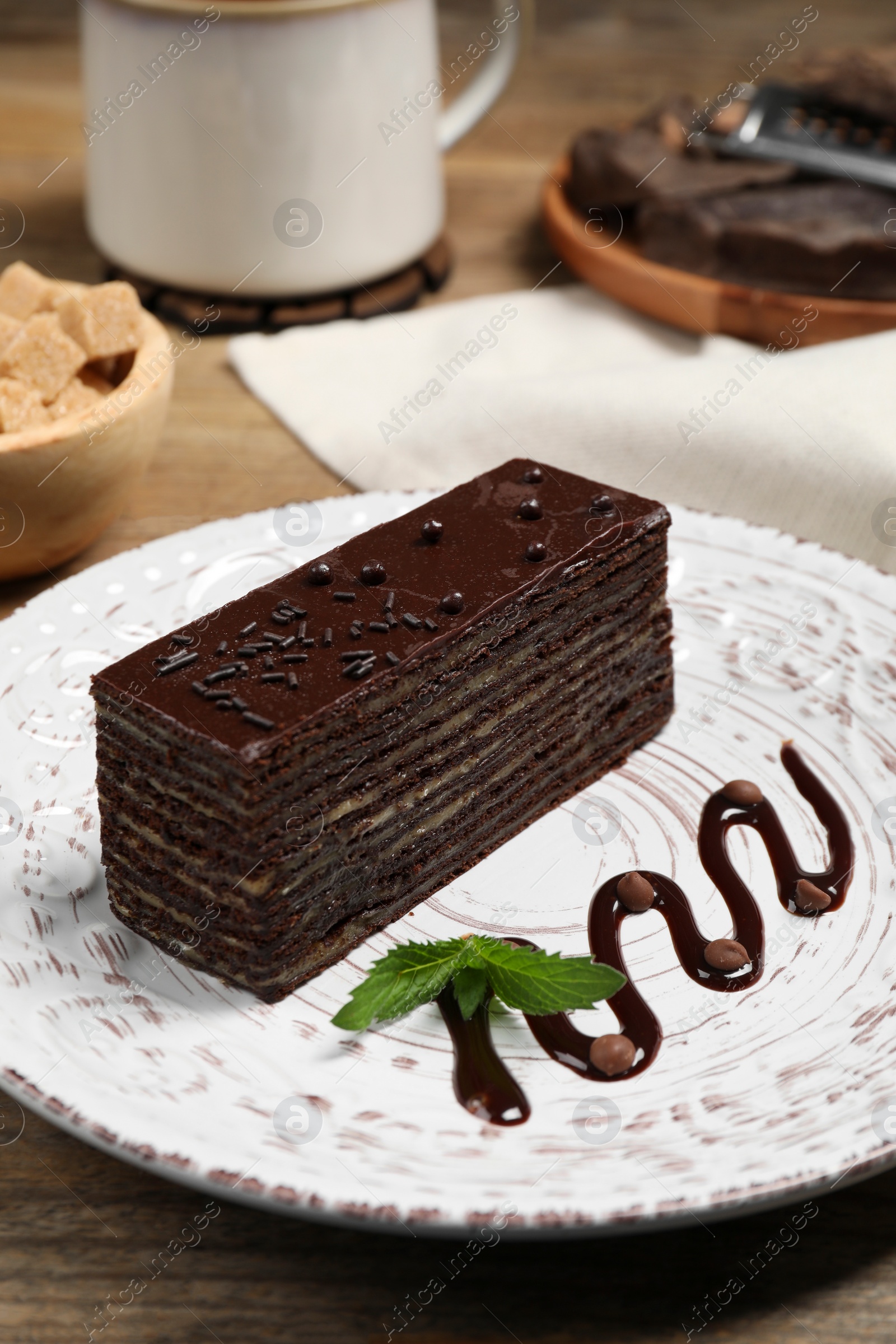 Photo of Tasty chocolate cake and mint on white plate