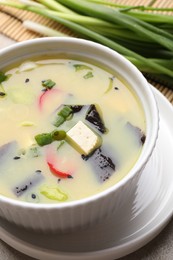 Bowl of delicious miso soup with tofu on table, closeup