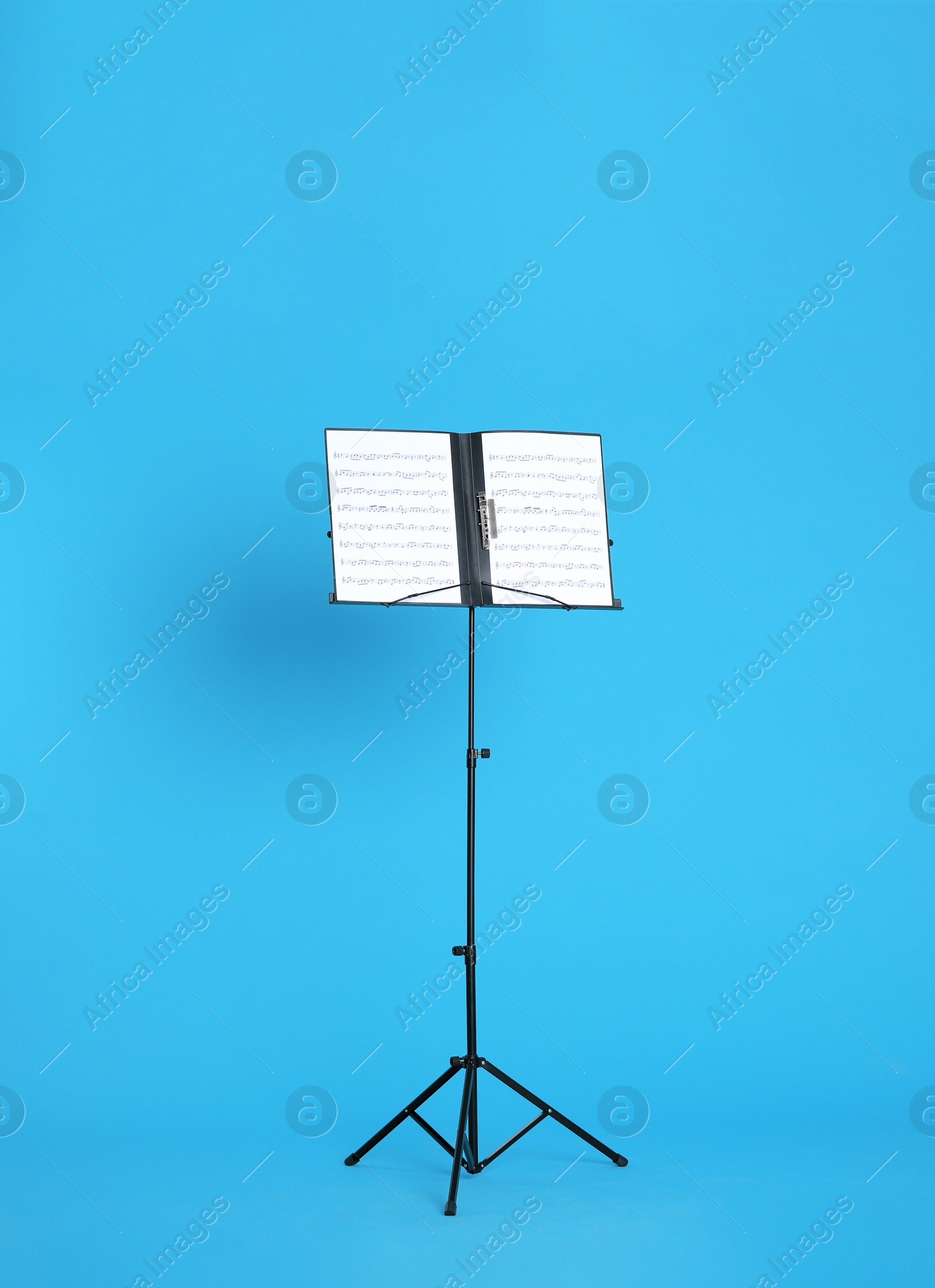 Photo of Note stand with music sheets on color background