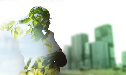 Image of Double exposure of businesswoman and green leaves in city