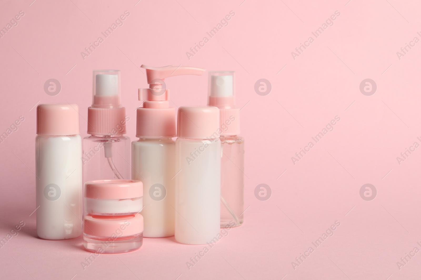 Photo of Cosmetic travel on pink background. Space for text