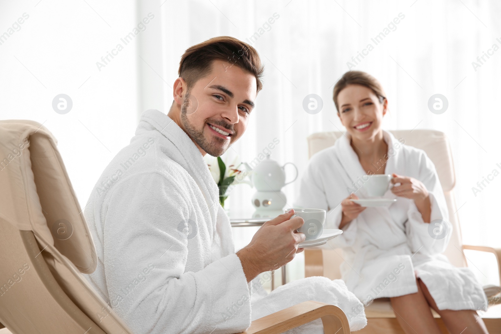 Photo of Romantic young couple with tea in spa salon