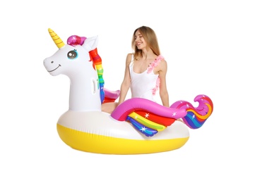 Photo of Beautiful young woman in stylish bikini with  unicorn inflatable ring on white background