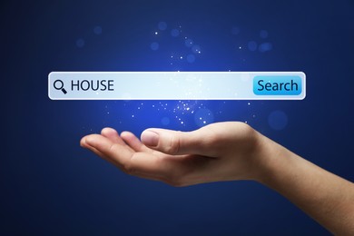 House hunting. Woman holding virtual search bar on blue background, closeup