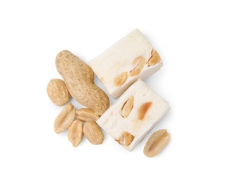 Pieces of delicious nougat and nuts on white background, top view